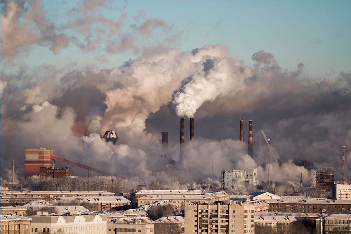 Chimeneas de fábricas en una ciudad expulsando gases nocivos